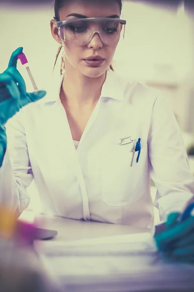 Femme chercheuse entourée de flacons et flacons médicaux, isolée sur fond blanc — Photo