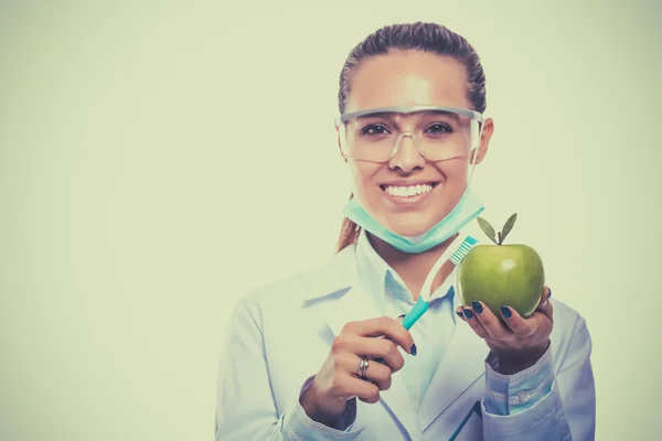 Médecin dentiste femme tenir vert pomme fraîche dans la main et brosse à dents — Photo