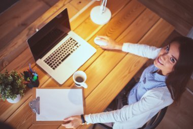 Masada oturan genç bir kadın.