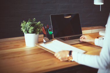 Masada oturan genç bir kadın.