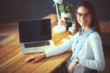 Masada oturan genç bir kadın.