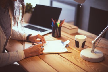 Masada oturan genç bir kadın.