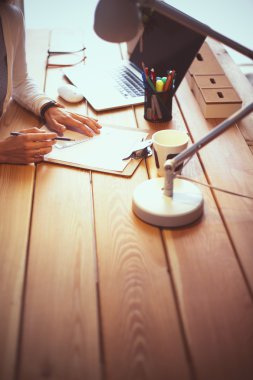 Masada oturan genç bir kadın.