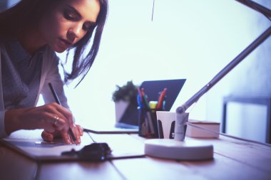 Masada oturan genç bir kadın.