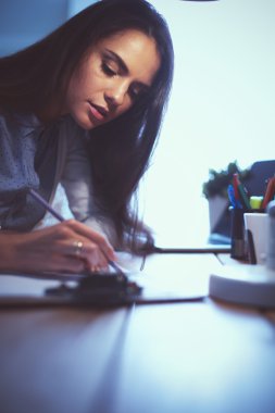 Masada oturan genç bir kadın.
