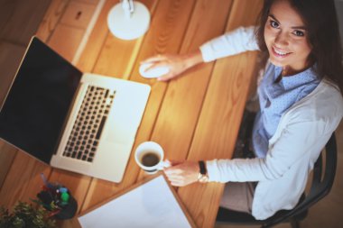 Masada oturan genç bir kadın.