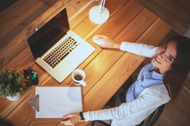 Masada oturan genç bir kadın.