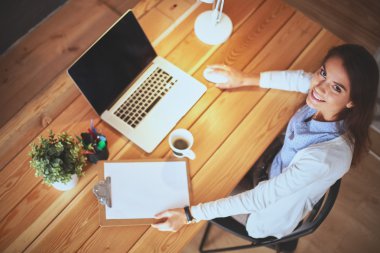 Masada oturan genç bir kadın.