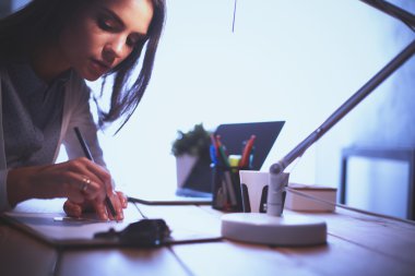 Masada oturan genç bir kadın.