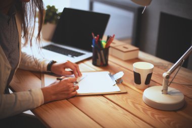 Masada oturan genç bir kadın.