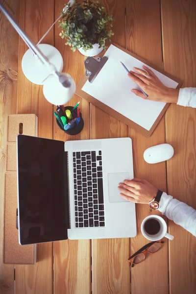 Jeune femme travaillant assise à un bureau — Photo