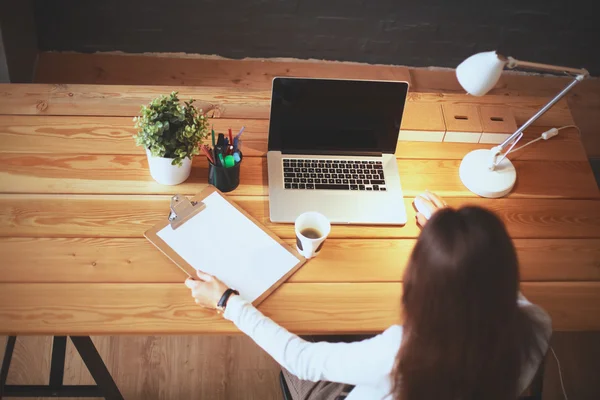 Jonge vrouw werkend zittend aan een bureau — Stockfoto