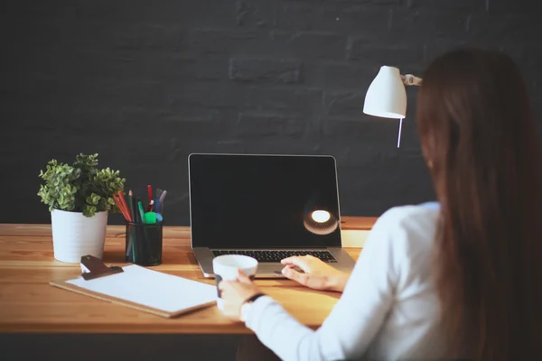 Jonge vrouw werkend zittend aan een bureau — Stockfoto