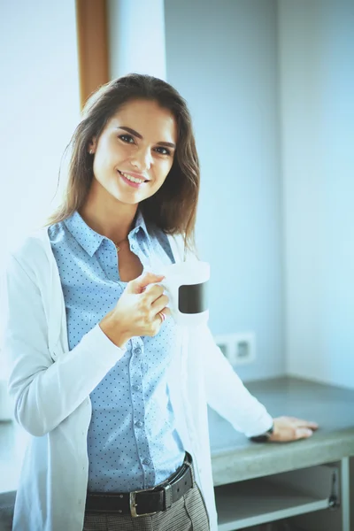 Gelukkige vrouw het drinken van thee in de keuken thuis — Stockfoto