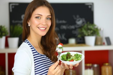 Salata yemek ve karışık salata tutan genç kadın