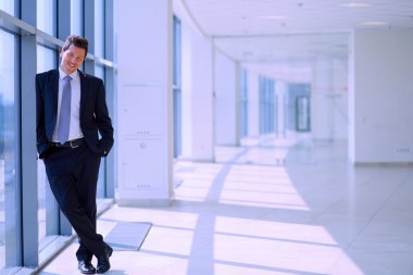 Koridorda pencere yakınındaki şirketi ayakta başarılı iş adamı