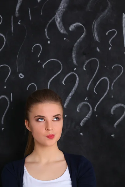 Young girl with question mark on a gray background — Stock Photo, Image