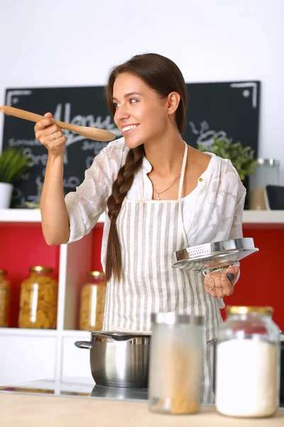 Mujer cocinera en cocina con cuchara de madera —  Fotos de Stock