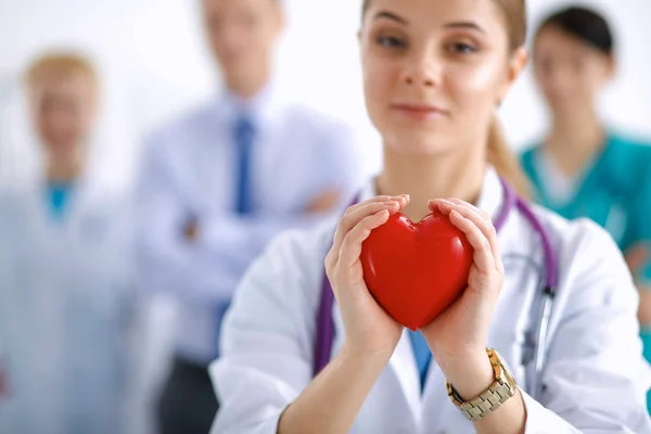 Νεαρή γυναίκα γιατρός κρατώντας μια κόκκινη καρδιά — Φωτογραφία Αρχείου