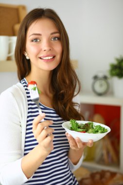 Salata yemek ve karışık salata tutan genç kadın