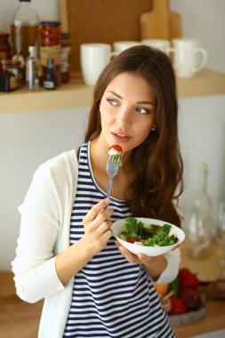 Salata yemek ve karışık salata tutan genç kadın