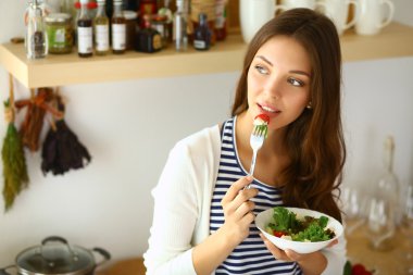 Salata yemek ve karışık salata tutan genç kadın