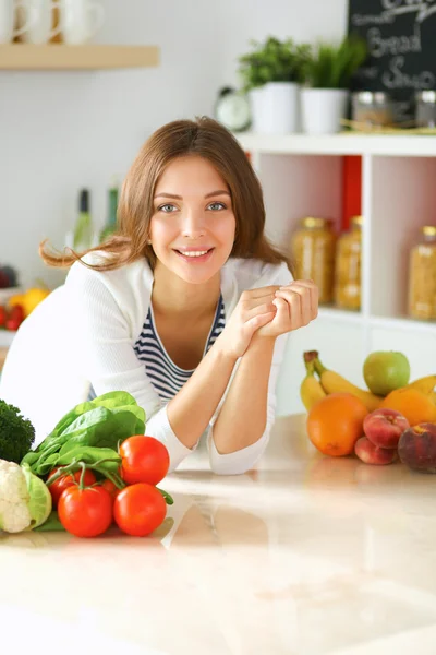 Young woman standing near desk in the kitchen — Stock Photo, Image