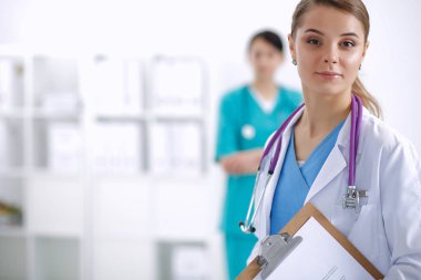 Kadın doktor hastanede dosyayla bekliyor.