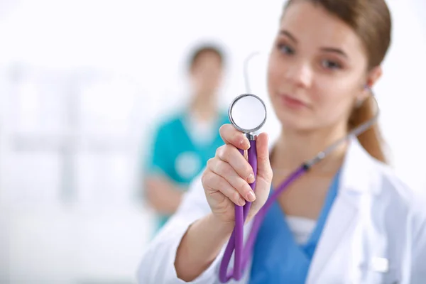 Молодая женщина-врач слушает стетоскоп, стоящий в больнице — стоковое фото