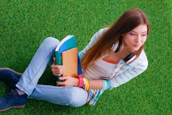 Vrouw lezing boek zit op het groene gras — Stockfoto