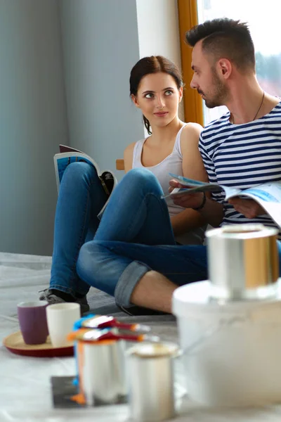 Paar zieht in Haus auf dem Fußboden sitzend ein — Stockfoto