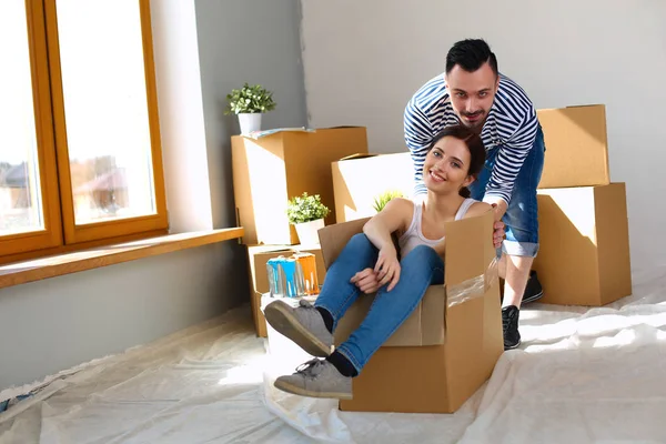 Happy young couple unpacking or packing boxes and moving into a new home — Stock Photo, Image