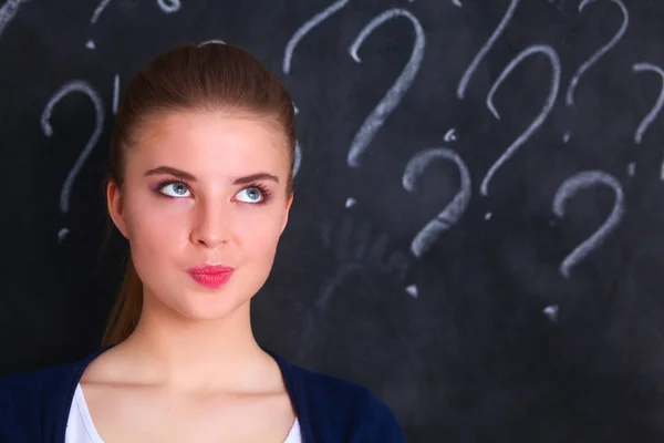 Jong meisje met vraagteken op een grijze achtergrond — Stockfoto