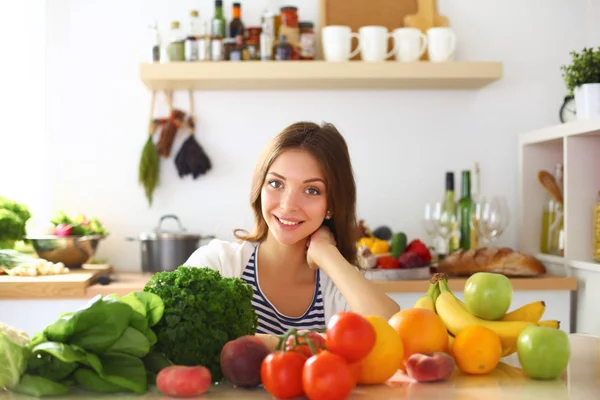 Jonge vrouw in de buurt van bureau in de keuken — Stockfoto