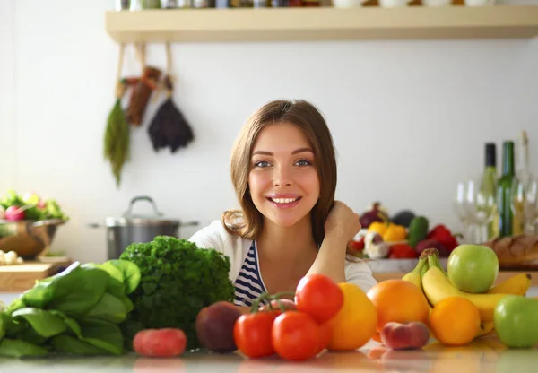 Jonge vrouw in de buurt van bureau in de keuken — Stockfoto