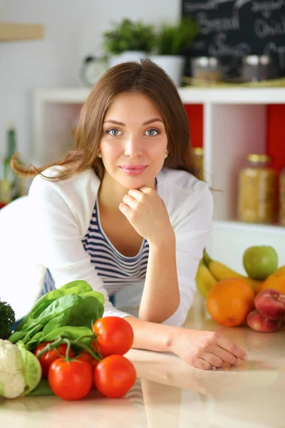 Young woman standing near desk in the kitchen Stock Photo