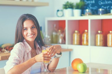 Mutfakta masada oturan genç bir kadın.