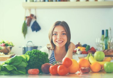 Mutfakta masanın yanında duran genç bir kadın.