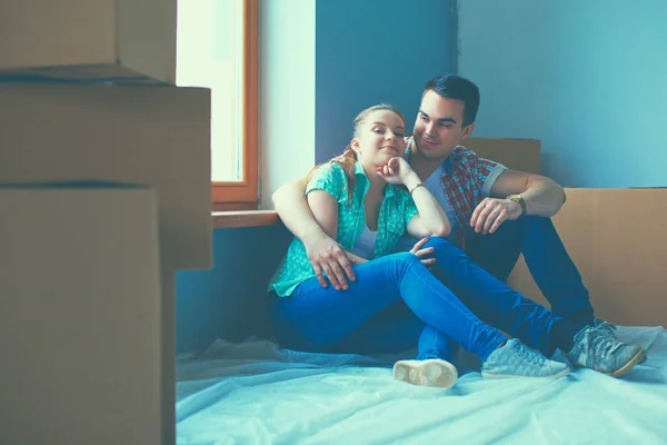 Пара переезжающих в дом, сидящих на полу — стоковое фото