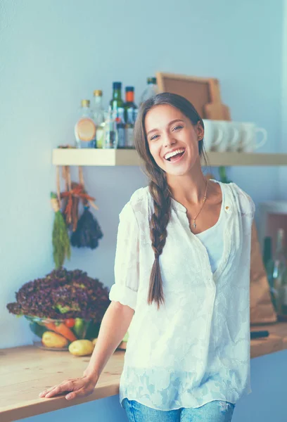 Young woman standing near desk in the kitchen — Stock Photo, Image