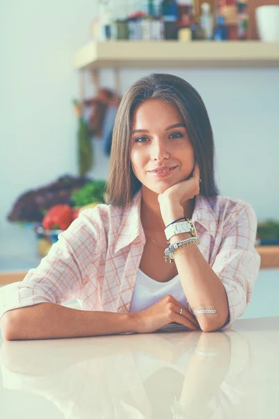 Jeune femme assise une table dans la cuisine — Photo