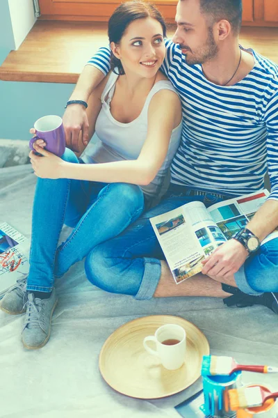 Casal em movimento em casa sentado no chão — Fotografia de Stock