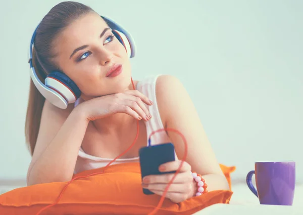 Young woman lying on floor and listen to music — Stock Photo, Image