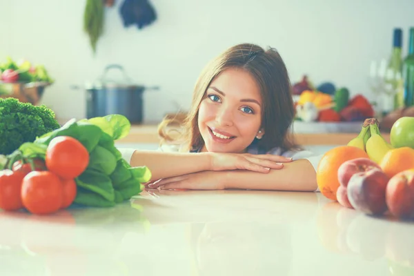 Junge Frau steht neben Schreibtisch in der Küche — Stockfoto