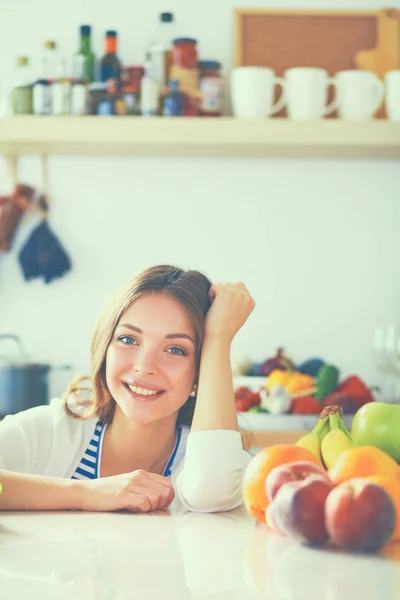 Jonge vrouw in de buurt van bureau in de keuken — Stockfoto