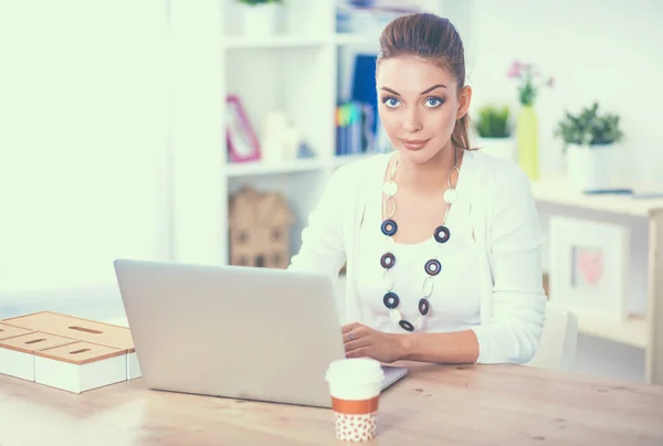 Attraente donna d'affari seduta su una scrivania con computer portatile in ufficio — Foto Stock