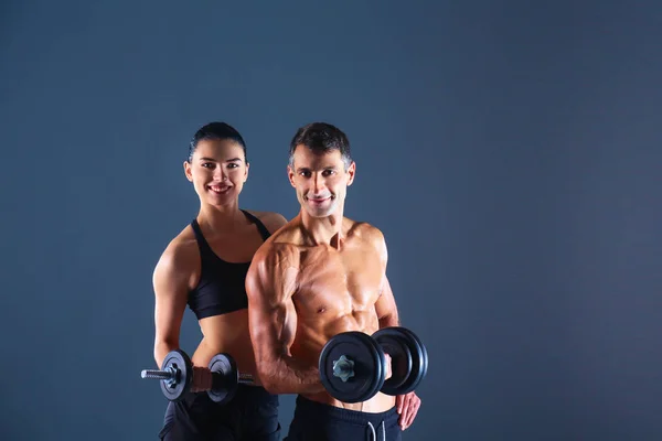 Hombre y mujer atléticos con mancuernas — Foto de Stock