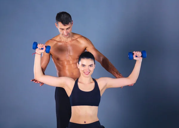 Hombre y mujer atléticos con mancuernas — Foto de Stock