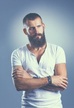 Ayakta, gri arka plan üzerinde izole yakışıklı adam portresi