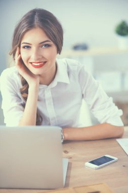 Ofiste dizüstü bilgisayarı olan çekici bir iş kadını.